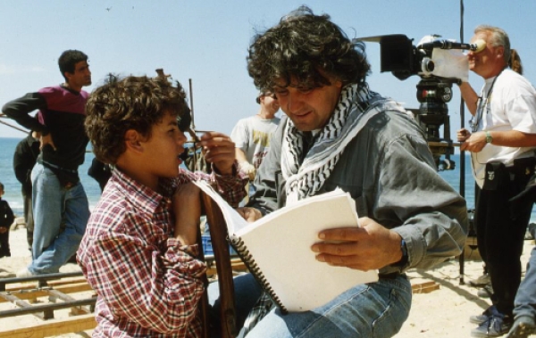 Michel Khleifi mit Drehbuch und Junge am Set