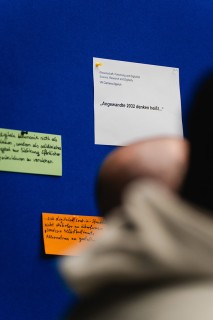 Detailaufnahme von Post its an einer blauen Pinnwand