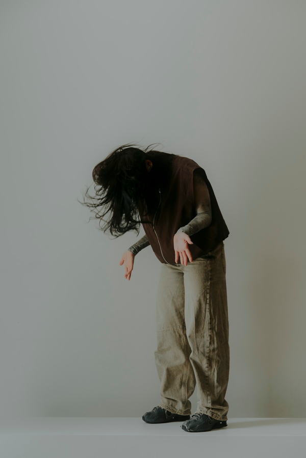 A
                                          person with their head bowed and their palms open and facing forward.