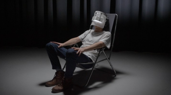 Mann sitzt auf einem Stuhl mit einer VR-Brille 