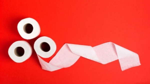 three rolls of toiletpaper on a red background