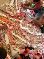 Kinder basteln am Boden künstlerisch mit Schnüren, Summer School im Rahmen des Projekts
                                          Lunik CoLab 