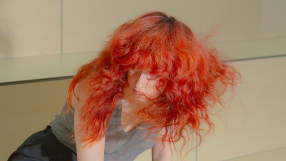 Eine Person mit roten Locken kniet.