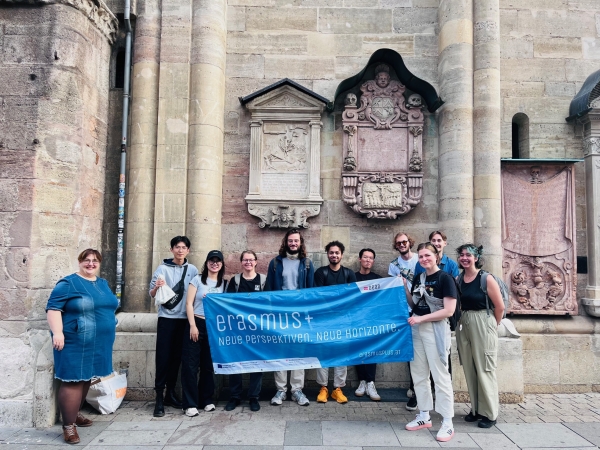 Veronika Merklein mit einer Gruppe von Studierenden am Stephansplatz, die die Erasmus+ Fahne vor sich halten