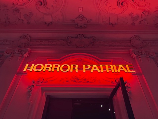 Leuchtschrift im Eingang mit dem Text Horror Patriae